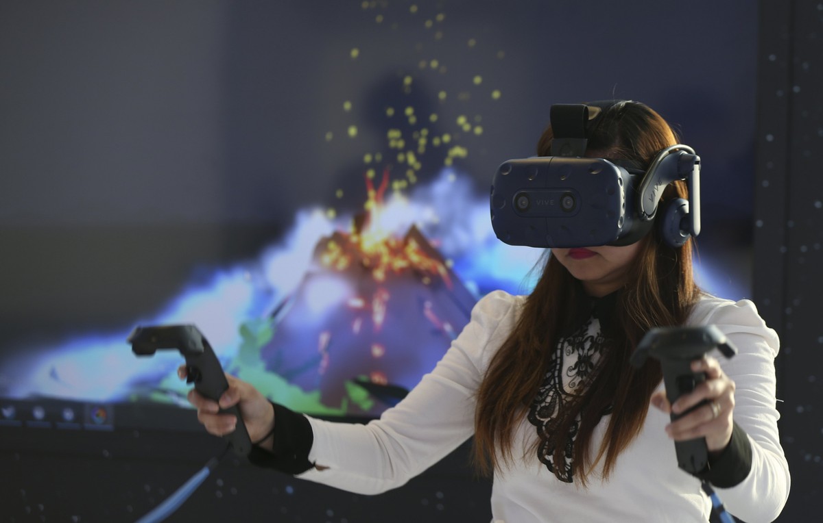 epa06662588 A woman experiences the new virtual reality (VR) headset 'HTC Vive Pro' during its launch event at Burj Khalifa in Dubai, United Arab Emirates, 11 April 2018. EPA/ALI HAIDER