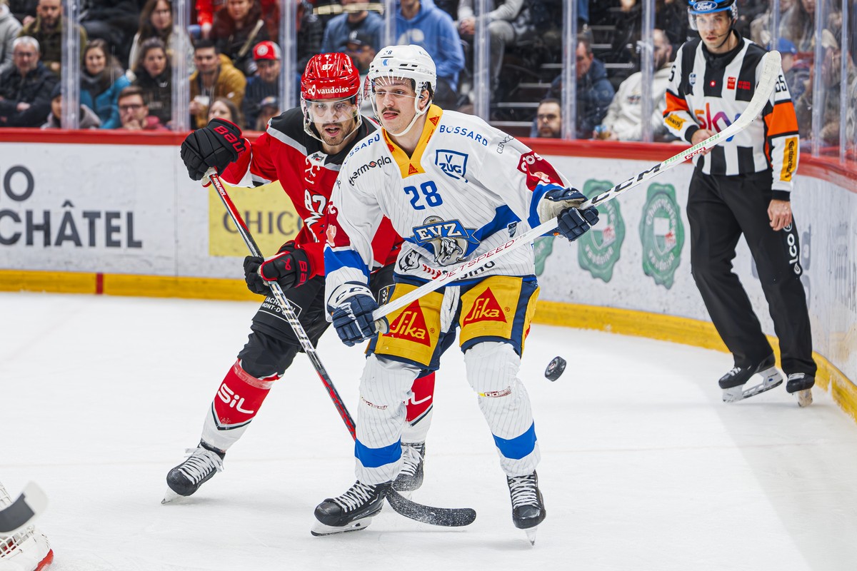 L'attaquant lausannois Marco Pedretti, gauche, lutte pour le puck avec l'attaquant zougois Dario Allenspach, droite, lors du match du championnat suisse de hockey sur glace de National Leagu ...
