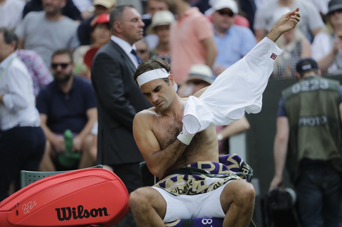 Switzerland's Roger Federer changes his t-shirt during his men's singles match against to Germany's Jan-Lennard Struff, on the fifth day of the Wimbledon Tennis Championships in London, ...