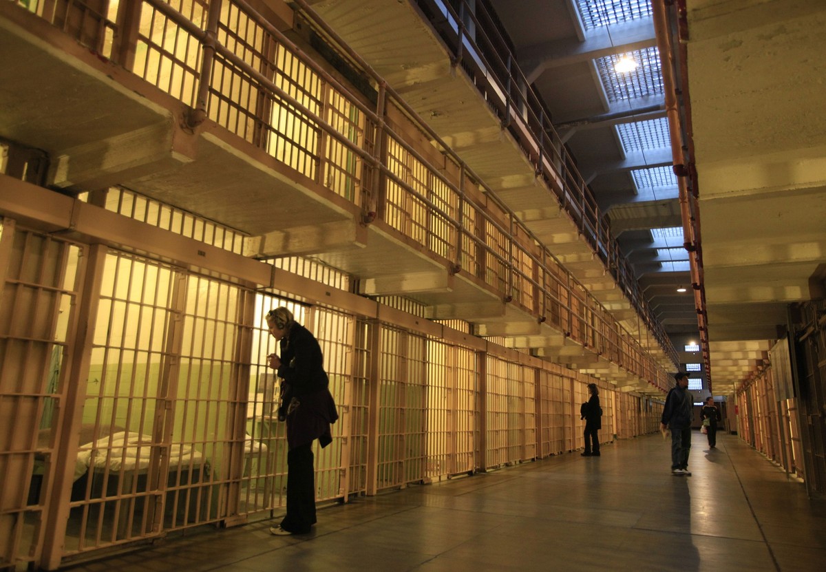 In this photo taken Thursday July 7, 2011, visitors look into cells in the main cell block during a night tour on Alcatraz Island in San Francisco. Most of the more than one million tourists who visit ...
