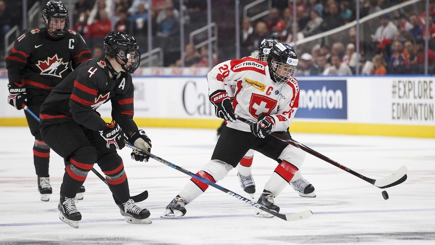 Canada&#039;s Bowen Byram (4) pursues Switzerland&#039;s Theo Rochette (20) during second period round-robin Hlinka Gretzky Cup hockey action in Edmonton, Alberta, Monday, Aug. 6, 2018. (Codie McLachl ...