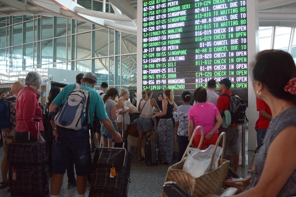 epa06353484 Passengers watch the information board at Bali's International Airport in Bali, Indonesia, 27 November 2017. According to media reports, the Indonesian national board for disaster manageme ...