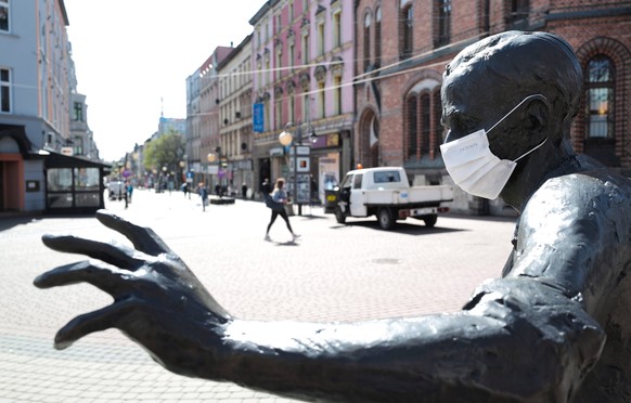 epa08366401 A monument of Polish soccer player Gerard Cieslik is adorned with a facial mask in Chorzow, southern Poland, 16 April 2020, during the coronavirus disease (COVID-19) pandemic. As a prevent ...