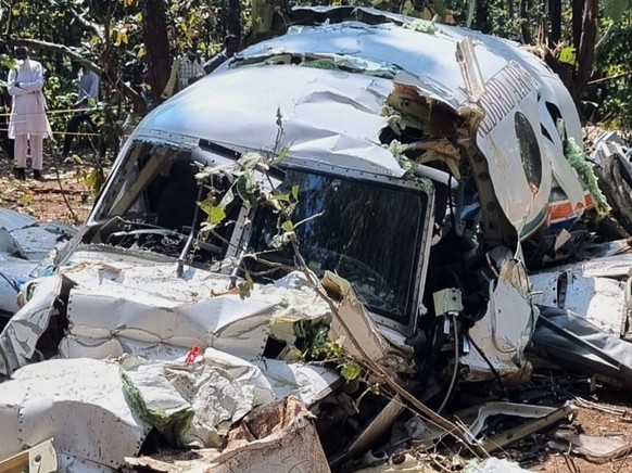 People watch wreckage of a Beechcraft C90 air ambulance aircraft after it crashed Monday into a forest near Ranchi, the capital of Indian state of Jharkhand, Tuesday, Feb.24, 2026. (AP Photo/Saikat Ch ...