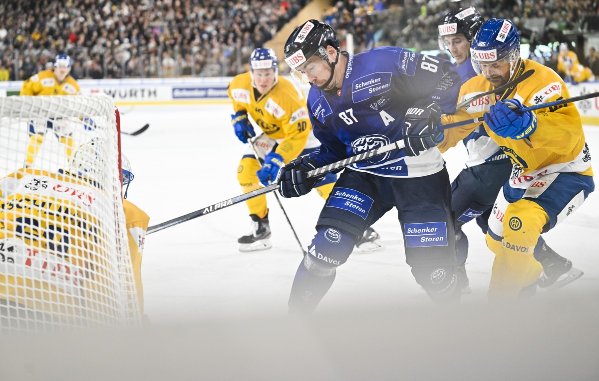 epa10382995 Davos' goalkeeper Sandro Aeschlimann, Ambri's Dario Buergler and Davos' Thomas Wellinger, from right, in action during the match between Switzerland's HC Ambri-Piotta a ...