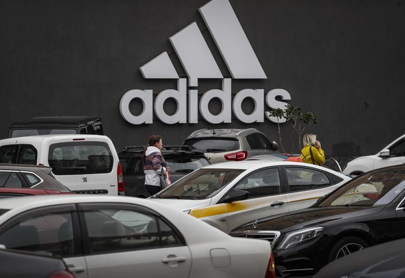 epa10181544 Russian people walks in front logo of Adidas in Moscow, Russia 13 September 2022. Adidas has suspended the work of its stores in Russia. As the result of sanctions imposed by the West on R ...