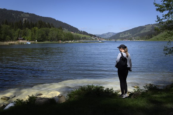 epa08428242 A woman enjoys the sun at the Black Lake (Schwarzsee), 1045 meters above sea level, in the Eastern Fribourg, Switzerland, Sunday, 17 May 2020. EPA/ANTHONY ANEX