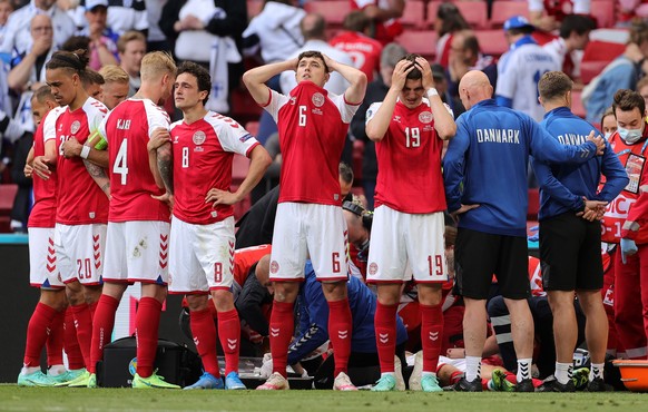 epa09618968 Players of Denmark react while their teammate Christian Eriksen receives medical treatment during the UEFA EURO 2020 group B preliminary round soccer match between Denmark and Finland in C ...