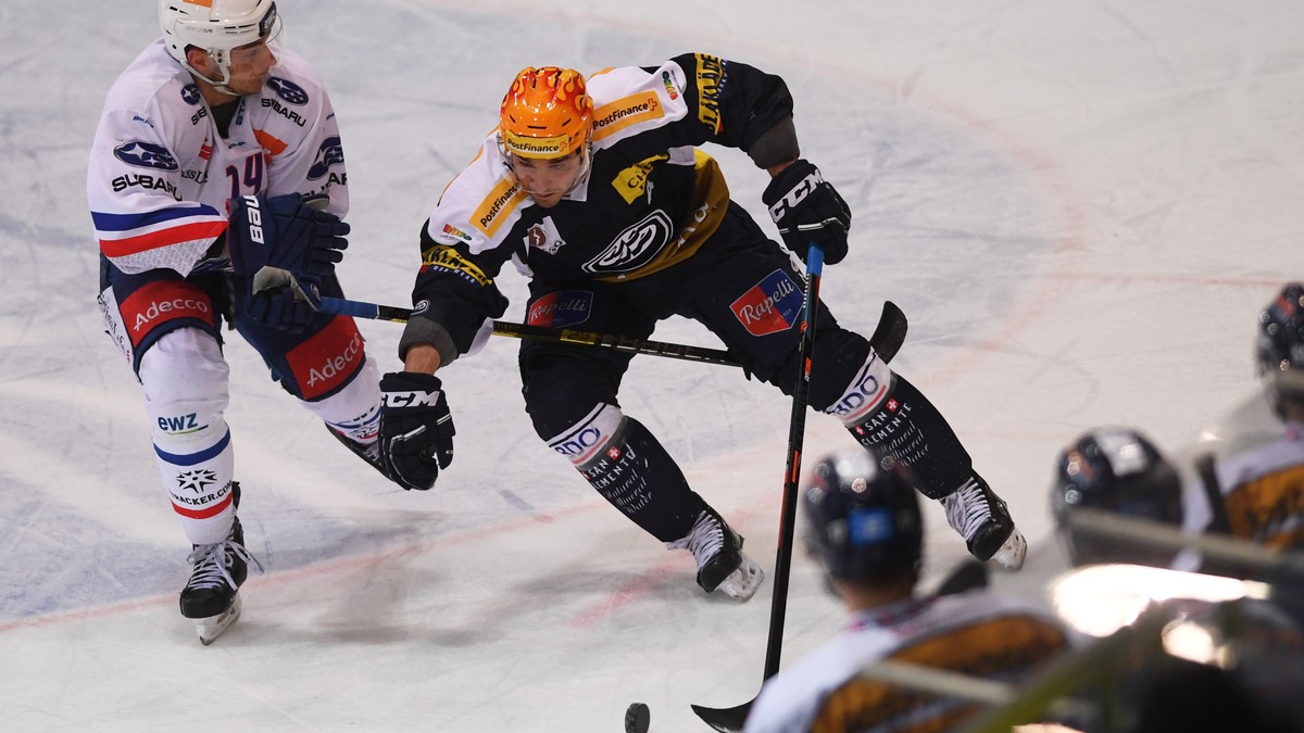 From left, Zurich's player Chris Baltisberger, fight for the puck with Ambri's Top Scorer Matt D'Agostini, during the preliminary round game of National League A (NLA) Swiss Championshi ...