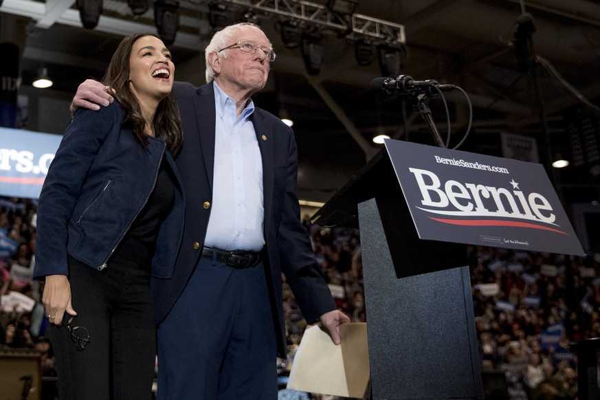 Democratic presidential candidate Sen. Bernie Sanders, I-Vt., accompanied by Rep. Alexandria Ocasio-Cortez, D-N.Y., left, takes the stage at campaign stop at the Whittemore Center Arena at the Univers ...