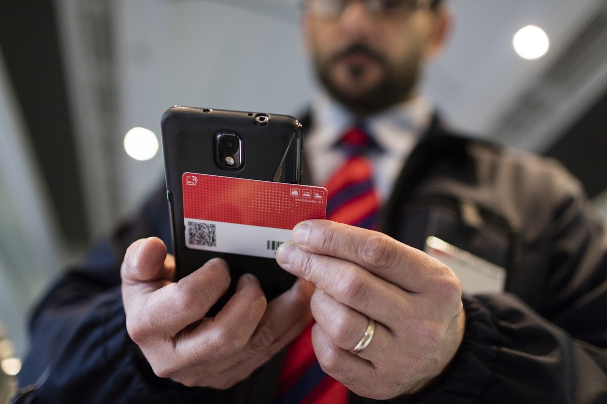 Train manager Salvatore Grado verifies a rail traveller's Swiss Pass in a Eurocity train of the Swiss Federal Railways bound from Zurich, Switzerland, to Milano, Italy, on October 3, 2015. (KEYST ...