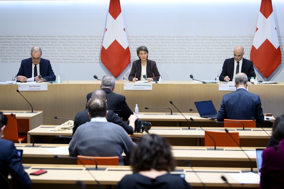 Bundespraesidentin Simonetta Sommaruga, Mitte, spricht an der Seite von Bundesrat Guy Parmelin, links, und Bundesrat Alain Berset, rechts, an einer Medienkonferenz, am Freitag, 18. Dezember 2020, im M ...