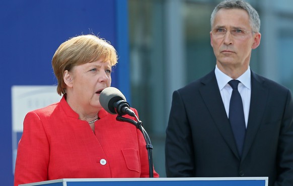 epa05989543 German Chancellor Angela Merkel (L) speaks next to NATO Secretary General Jens Stoltenberg (R) during the unveiling of a monument at the new NATO Headquarters during the NATO summit in Bru ...