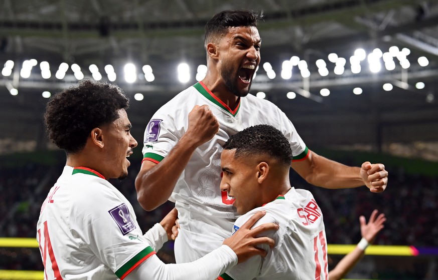 epa10332401 Abdelhamid Sabiri (bottom R) of Morocco celebrates with teammates after scoring the 1-0 lead during the FIFA World Cup 2022 group F soccer match between Belgium and Morocco at Al Thumama S ...