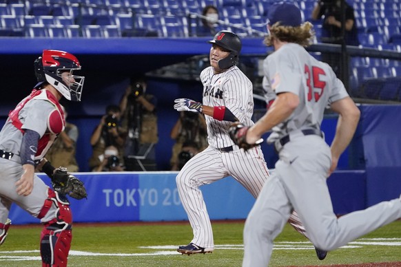 Japan&#039;s Hayato Sakamoto, center, scores during a baseball game against the United States at the 2020 Summer Olympics, Monday, Aug. 2, 2021, in Yokohama, Japan. (AP Photo/Sue Ogrocki)