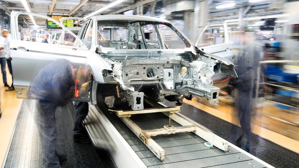 ARCHIV --- Mitarbeiter montieren am 1. Maerz 2019 Kotfluegel an einen Volkswagen Golf VII im Karosseriebau im VW Werk in Wolfsburg, Deutschland. (Aufnahme mit langer Verschlusszeit). (zu dpa &quot;Vol ...