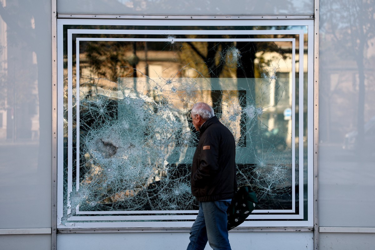 Un passant longe une vitrine brisée, au lendemain d’une manifestation pour le pouvoir d’achat, la défense des services publics et la justice fiscale et sociale, à Paris, le 25 octobre 2026. (Photo by  ...