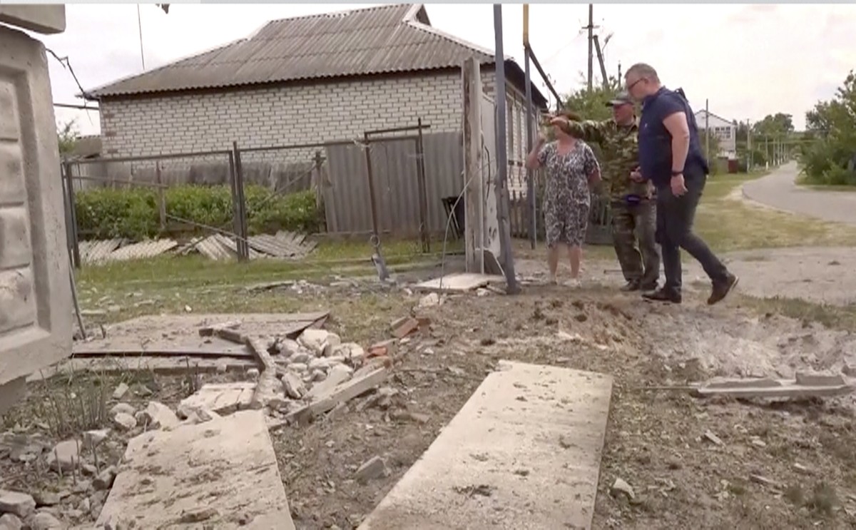 This image taken from a video shows people indicating a damaged building in the Belgorod region, Russia, Monday, May 22, 2023. Russian troops and security forces fought for a second day Tuesday agains ...