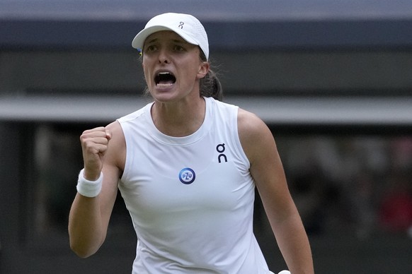 Poland&#039;s Iga Swiatek celebrates after beating Switzerland&#039;s Belinda Bencic in a women???s singles match on day seven of the Wimbledon tennis championships in London, Sunday, July 9, 2023. (A ...