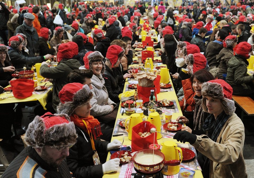 Gegen 800 Personen stellen am Samstag, 12. Januar 2013, in der Halle des Hauptbahnhofes Zuerich einen neuen Weltrekord im Fondue-Essen auf. (KEYSTONE/Steffen Schmidt)