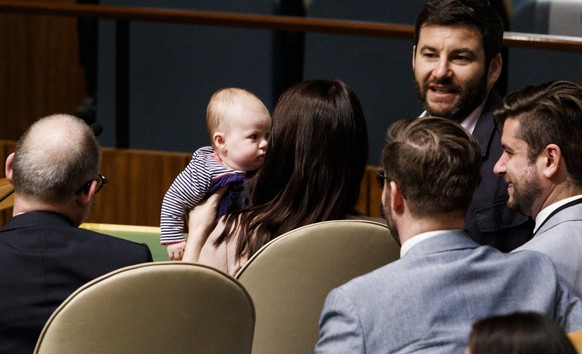 epa07043964 New Zealand Prime Minister Jacinda Ardern (C) holds her daughter Neve (C) while sitting with her partner Clarke Gayford (2-R) and her delegation after speaking at the Nelson Mandela Peace  ...