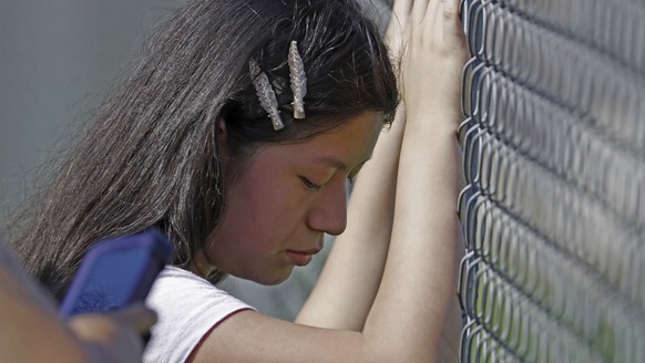 This young woman cries while standing outside the Koch Foods Inc., plant as U.S. immigration officials raid the plant in Morton, Miss., Wednesday, Aug. 7, 2019. U.S. immigration officials raided sever ...