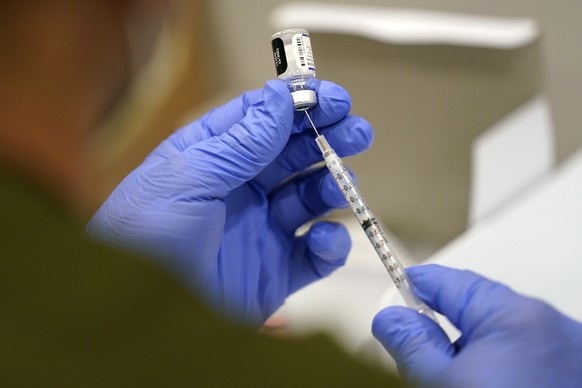 FILE - A healthcare worker fills a syringe with the Pfizer COVID-19 vaccine at Jackson Memorial Hospital on Oct. 5, 2021, in Miami. Lawyers for a group of Navy SEALS and other Navy personnel who oppos ...