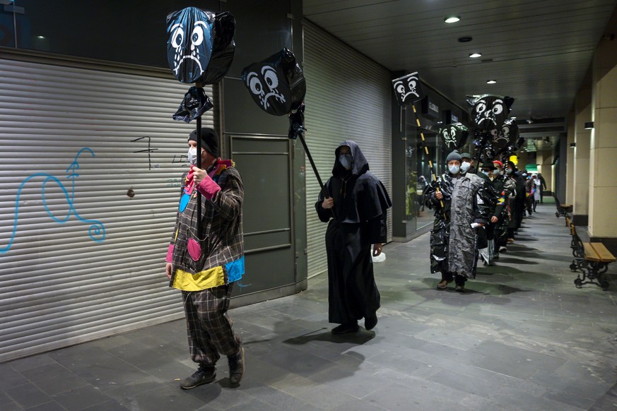 Fasnaechtler mit spazieren mit Mundschutz und eingehuellten Laternen durch die Stadt am nicht stattfindenden Morgestraich in Basel, am Montag Morgen um 04:00 Uhr, am 2. Maerz 2020. Die Behoerden hatte ...