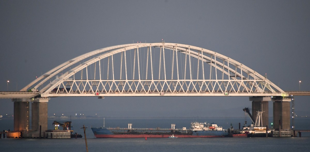 A ship under the the Kerch bridge blocks the passage to the Kerch Strait near Kerch, Crimea, Sunday, Nov. 25, 2018. Russia and Ukraine traded accusations over an incident at sea Sunday near the disput ...