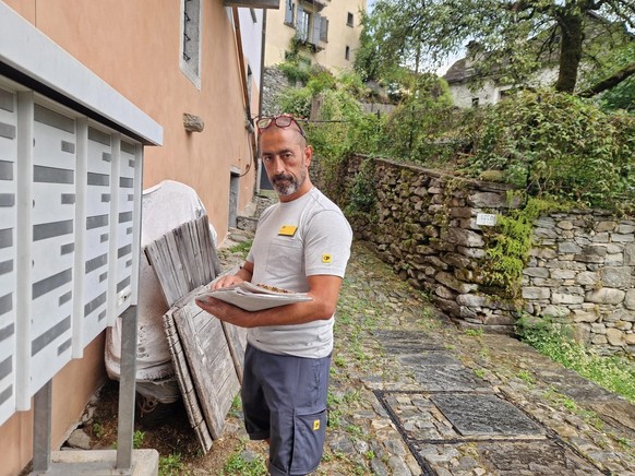 Pöstler Michele Celli im Einsatz. Bei einigen Kunden gehört ein kurzer Schwatz zum Service dazu.