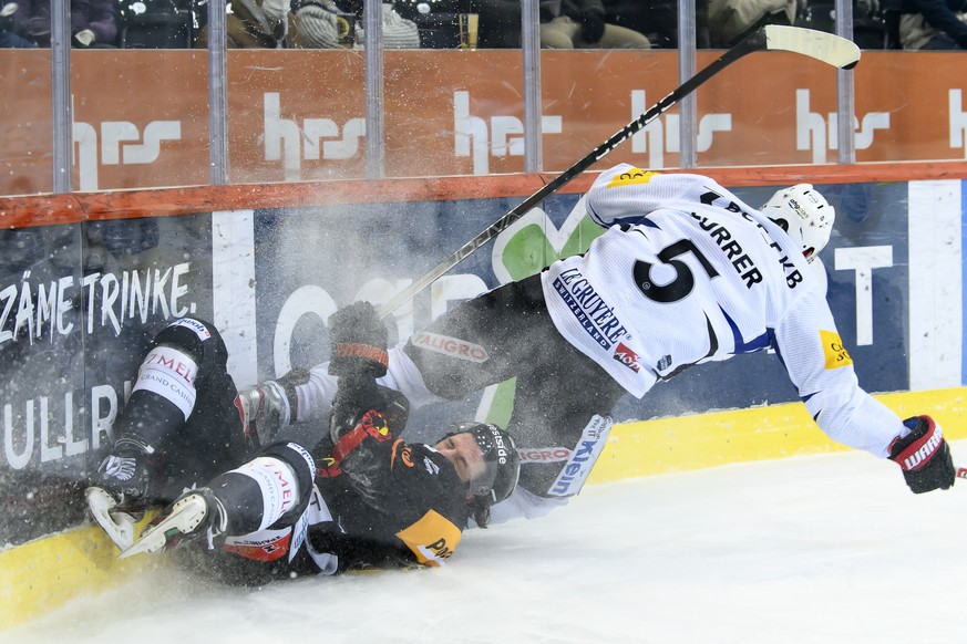 Berns Christian Thomas, links, und Gotterons Philippe Furrer, rechts, kaempfen um den Puck, beim Eishockey Meisterschaftsspiel der National League zwischen dem SC Bern und HC Fribourg Gotteron, am Fre ...