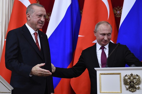 epa07312959 Russian President Vladimir Putin (R) and Turkish President Recep Tayyip Erdogan (L) leave after a joint press conference following their talks at the Kremlin in Moscow, Russia, 23 January  ...