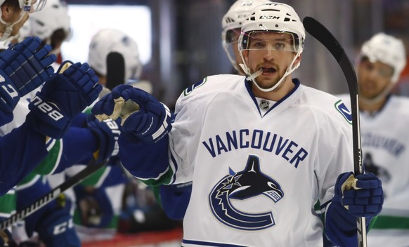 Vancouver Canucks left wing Sven Baertschi, of the Czech Republic, is congratulated as he passes the team box after scoring the go-ahead goal against the Colorado Avalanche during the third period of  ...