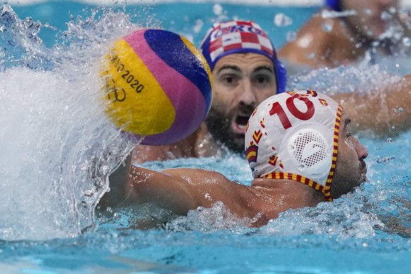 Spain&#039;s Felipe Perrone Rocha (10) moves the ball past Croatia&#039;s Javier Garcia Gadea, top, during a preliminary round men&#039;s water polo match at the 2020 Summer Olympics, Monday, Aug. 2,  ...