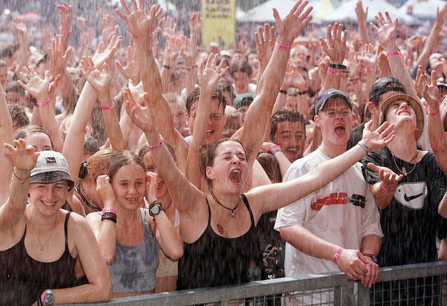 Willkommene Abkuehlung am 22. Open Air St. Gallen vom 27. Juni 1998 im Sittertobel. Auch Regen und Hagel im Wechsel mit Sonnenschein und hohen Temperaturen vermochten die Stimmung im Sittertobel nicht ...