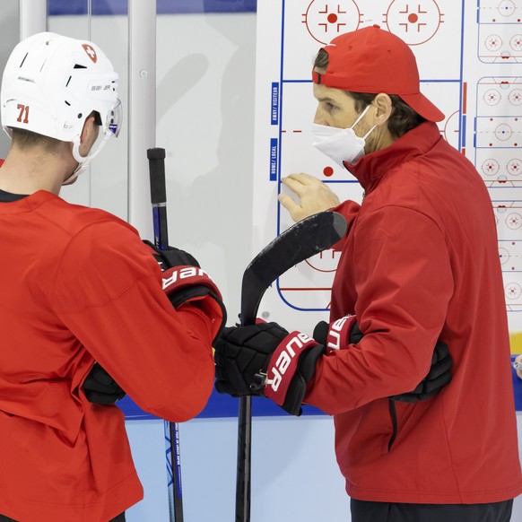 Patrick Fischer, center, head coach of Switzerland national ice hockey team, talks to his player forward Enzo Corvi, left, past Christian Wohlwend, right, assistant coach, during a training of the Swi ...