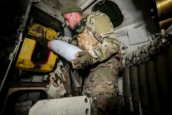 epa10978498 A Ukrainian serviceman of the 65th mechanized brigade loads a shell inside a Soviet-made 2s1 Gvozdyka 120mm howitzer in the Zaporizhia region, Ukraine, 15 November 2023, amid the Russian i ...
