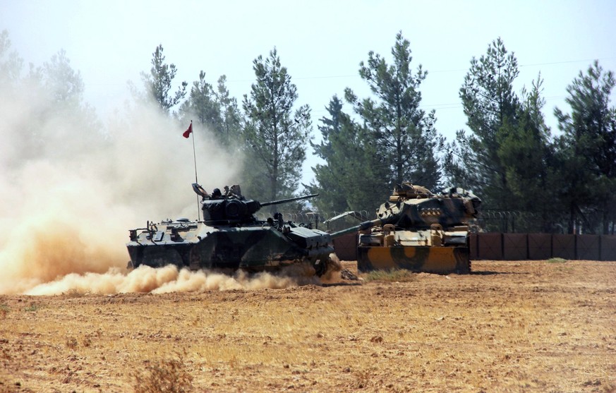 A Turkish army tank and an armored vehicle are stationed near the border with Syria, in Karkamis, Turkey, Tuesday, Aug. 23, 2016. Turkish media reports say Turkish artillery on Tuesday launched new st ...