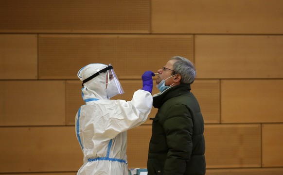 A medical staff member takes nasal swabs at a school set up as a testing facility in Bolzano, northern Italy, Friday, Nov. 20, 2020. Citizens in ItalyÄôs small Germany-speaking province of South Tyro ...