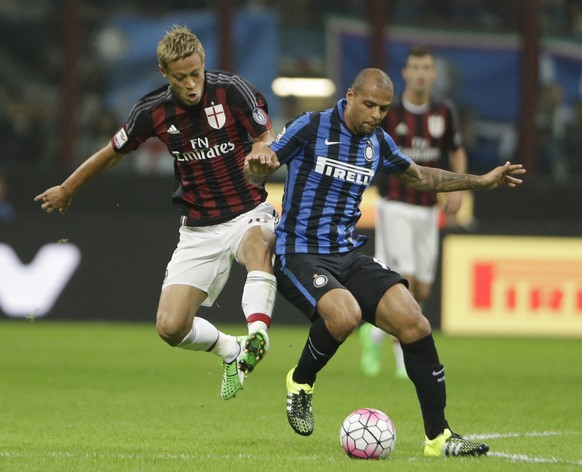 AC Milan&#039;s Keisuke Honda, left, challenges for the ball with Inter Milan&#039;s Felipe Melo during a Serie A soccer match between Inter Milan and AC Milan, at the San Siro stadium in Milan, Italy ...