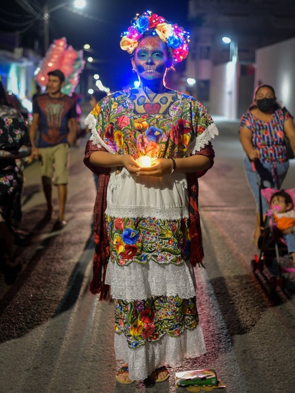 PROGRESO, MEXICO - NOVEMBER 1: Persons dressed with colorful regional clothing and faces painted as skulls take part during the &#039;Walk of the Souls&#039; as part of Mexico&#039;s Day of the Dead ( ...