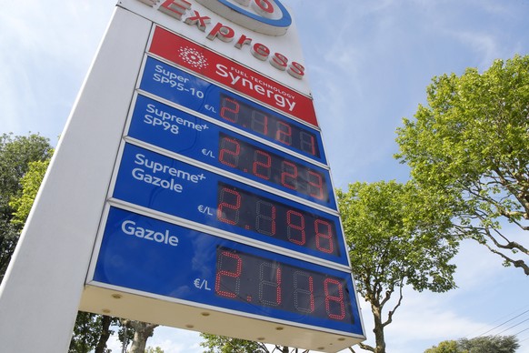The per-liter prices for gasoline and diesel fuel are displayed in front of a filling station, (2.11 Euros equivalent to 2.20 US dollar), in Lille, northern France, Wednesday, June. 15, 2022. People a ...