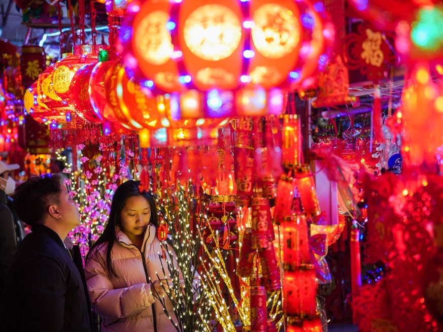 epa10415426 People buy decorations of red lanterns and couplets ahead of the upcoming Chinese Lunar New Year in Nanning, Guangxi Zhuang Autonomous Region, China, 19 January 2023. Chinese lunar new yea ...