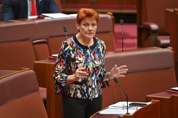 epa12546980 One Nation Leader Pauline Hanson speaks in the Senate chamber at Parliament House in Canberra, Australia, 25 November 2025. Hanson was suspended from senate for seven days for wearing a bu ...