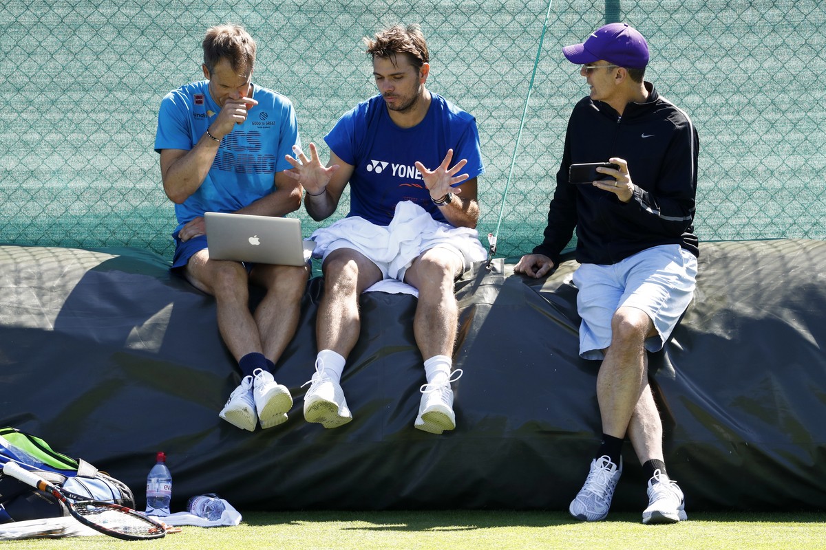 Stan Wawrinka of Switzerland, center, in discussion with his coaches Paul Annacone, right, and Magnus Norman, left, during a training session at the All England Lawn Tennis Championships in Wimbledon, ...