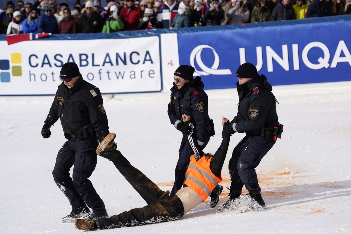 A protester of Last Generation is dragged away after spraying paint in the finish area of an alpine ski, men's World Cup slalom in Gurgl, Austria, Saturday, Nov. 18, 2023. (AP Photo/Piermarco Tac ...