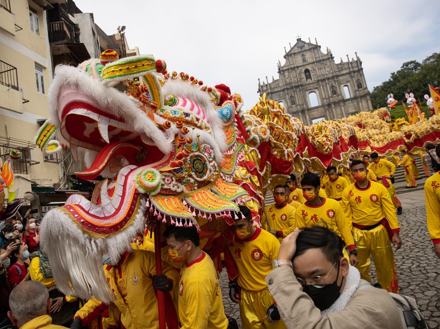 epa10421880 Worshippers perform a dragon dance to celebrate the Chinese lunar new year in Macau, China, 22 January 2023. Macau borders reopened earlier this month and the city has launched a promotion ...