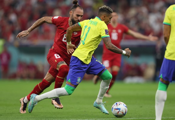 epa10326075 Raphinha (R) of Brazil in action against Nemanja Gudelj of Serbia during the FIFA World Cup 2022 group G soccer match between Brazil and Serbia at Lusail Stadium in Lusail, Qatar, 24 Novem ...