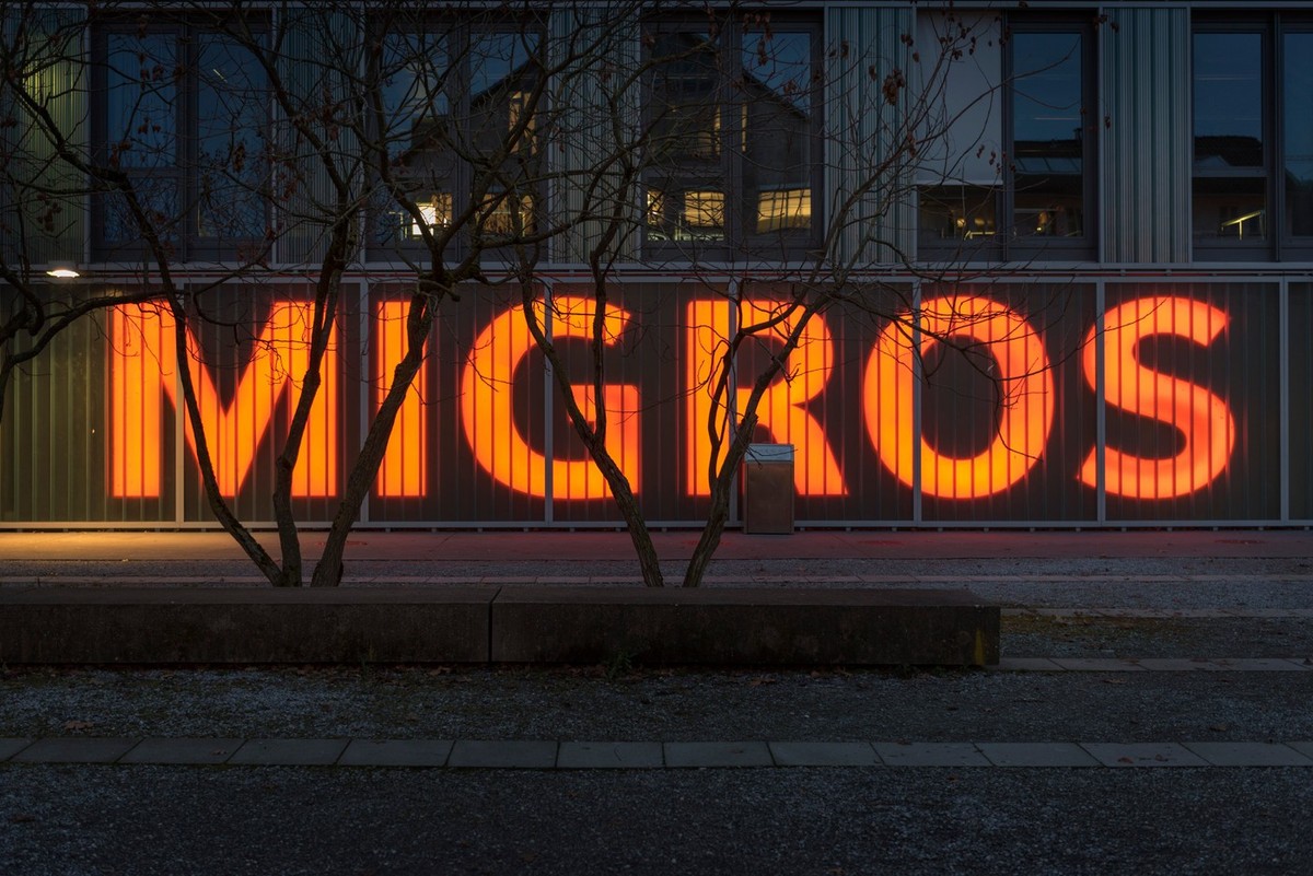 Leuchtendes Migros-Logo.