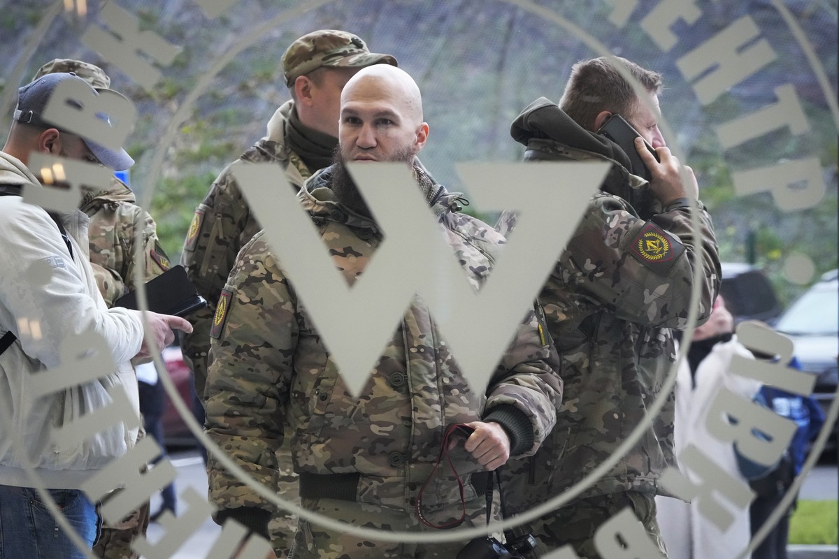 Visitors wearing military camouflage stand at the entrance of the 'PMC Wagner Centre', which is associated with businessman and founder of the Wagner private military group Yevgeny Prigozhin ...